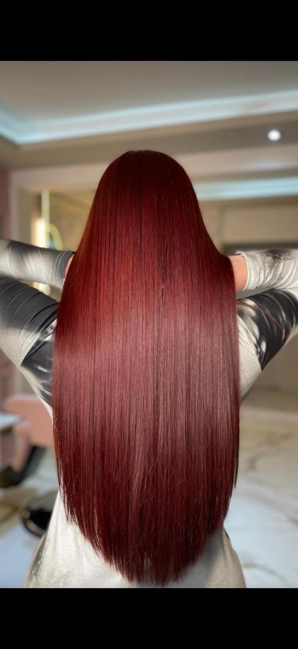 Resultado de alaciado en cabello largo color rojo cereza